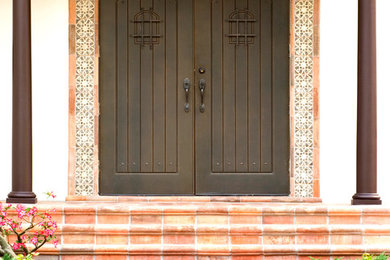 Photo of a small mediterranean front door in Tampa with beige walls, a double front door and a dark wood front door.