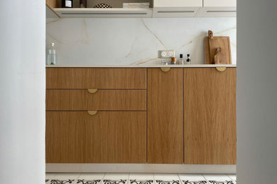 Exemple d'une cuisine linéaire, haussmannienne et blanche et bois tendance fermée avec un plan de travail en quartz modifié, une crédence en quartz modifié et carreaux de ciment au sol.