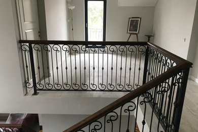 Стильный дизайн: п-образная лестница в классическом стиле с деревянными ступенями, металлическими перилами и обоями на стенах без подступенок - последний тренд