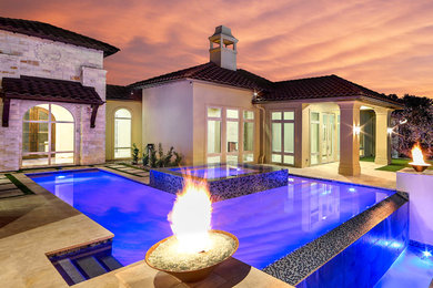 Inspiration for a huge modern backyard l-shaped lap hot tub remodel in Austin with decking
