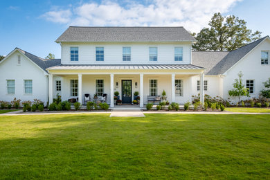 Example of a large cottage two-story concrete fiberboard house exterior design in Little Rock with a metal roof and a black roof
