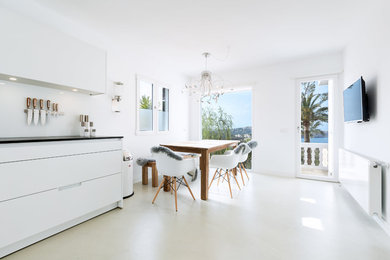 Inspiration for a mid-sized mediterranean kitchen/dining combo in Palma de Mallorca with white walls, concrete floors and no fireplace.