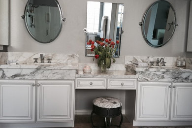 Inspiration for a mid-sized transitional master bathroom in Atlanta with beaded inset cabinets, white cabinets, an alcove tub, an alcove shower, a two-piece toilet, grey walls, porcelain floors, an undermount sink, marble benchtops, grey floor and a hinged shower door.