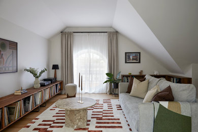 Inspiration for a mid-century modern medium tone wood floor, brown floor and vaulted ceiling living room remodel in Other with white walls