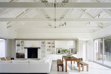 Huge trendy white floor living room photo in New York with white walls and a brick fireplace
