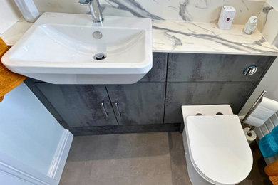 Mid-sized modern kids bathroom in Other with flat-panel cabinets, grey cabinets, an open shower, a one-piece toilet, white walls, laminate floors, a drop-in sink, laminate benchtops, grey floor, an open shower, multi-coloured benchtops, a single vanity and a built-in vanity.