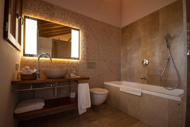 Ejemplo de cuarto de baño romántico con losas de piedra, paredes beige, suelo de mármol y lavabo sobreencimera