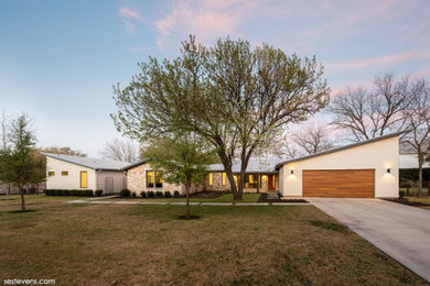 Mittelgroßes, Einstöckiges Modernes Einfamilienhaus mit Mix-Fassade, beiger Fassadenfarbe, Satteldach, Blechdach, grauem Dach und Verschalung in Austin