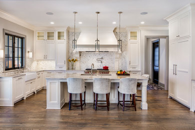Large elegant u-shaped medium tone wood floor and brown floor eat-in kitchen photo in Charlotte with a farmhouse sink, beaded inset cabinets, white cabinets, granite countertops, gray backsplash, marble backsplash, paneled appliances, an island and gray countertops