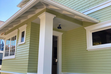 Imagen de fachada de casa verde de estilo americano de dos plantas con revestimiento de madera