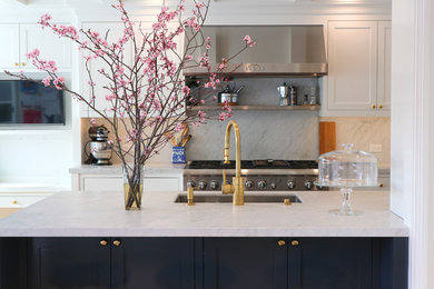 Eat-in kitchen - mid-sized traditional medium tone wood floor and brown floor eat-in kitchen idea in San Francisco with an undermount sink, shaker cabinets, white cabinets, marble countertops, white backsplash, marble backsplash, stainless steel appliances and a peninsula