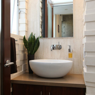 Idee per un bagno di servizio minimalista di medie dimensioni con lavabo a bacinella, ante con riquadro incassato, pareti beige, ante in legno bruno, piastrelle beige, piastrelle in travertino, top in quarzo composito e top marrone