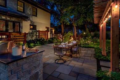 Photo of a large traditional backyard patio in Chicago with a fire feature and natural stone pavers.