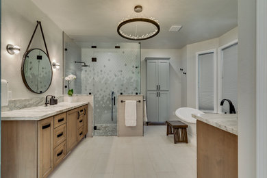 Example of a large farmhouse master beige tile and ceramic tile porcelain tile, white floor and double-sink bathroom design in Other with shaker cabinets, medium tone wood cabinets, white walls, an undermount sink, quartzite countertops, a hinged shower door, beige countertops and a built-in vanity