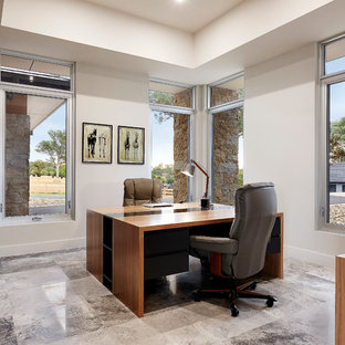 Exempel på ett mellanstort modernt hemmabibliotek, med grå väggar, kalkstensgolv och ett fristående skrivbord