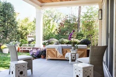 Photo of an expansive transitional backyard verandah in DC Metro with brick pavers and a roof extension.