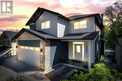 Example of a large arts and crafts blue two-story concrete fiberboard and clapboard exterior home design in Other with a shingle roof and a black roof