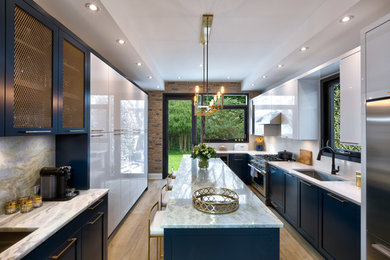 Small trendy galley light wood floor and yellow floor eat-in kitchen photo in Toronto with an undermount sink, flat-panel cabinets, blue cabinets, quartzite countertops, white backsplash, slate backsplash, stainless steel appliances and an island