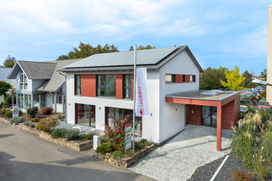 Large contemporary two floor render detached house in Stuttgart with a pitched roof, a tiled roof and a grey roof.