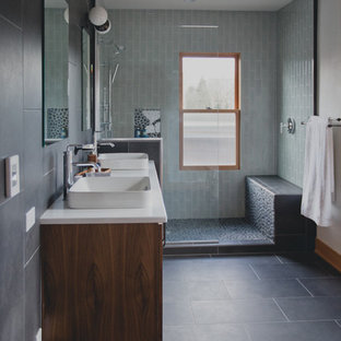 Imagen de cuarto de baño principal, tradicional renovado, de tamaño medio, con paredes blancas, suelo de baldosas de porcelana, armarios con paneles lisos, ducha abierta, sanitario de una pieza, baldosas y/o azulejos grises, baldosas y/o azulejos de porcelana, lavabo integrado, encimera de cuarzo compacto y puertas de armario de madera oscura