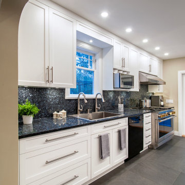 Functional & Stylish White Kitchen with Dark Countertops and Backsplash