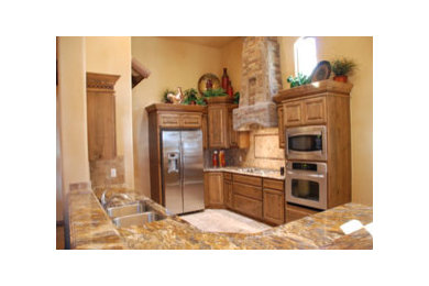Immagine di una cucina stile americano con lavello sottopiano, ante con bugna sagomata, ante con finitura invecchiata, top in granito, paraspruzzi beige e elettrodomestici in acciaio inossidabile