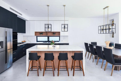 Photo of a large modern l-shaped open plan kitchen in Sydney with an undermount sink, shaker cabinets, black cabinets, marble benchtops, multi-coloured splashback, marble splashback, black appliances, porcelain floors, with island, grey floor, multi-coloured benchtop and coffered.