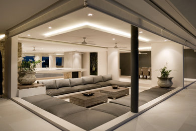 Inspiration for a large modern formal and open concept concrete floor, beige floor and tray ceiling living room remodel in San Diego with beige walls and a media wall