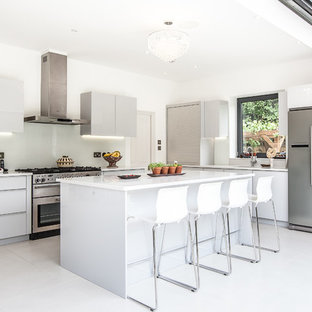 Foto de cocina contemporánea con fregadero de doble seno, armarios con paneles lisos, puertas de armario blancas, salpicadero blanco y electrodomésticos de acero inoxidable