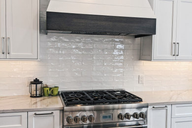 Example of a large farmhouse u-shaped dark wood floor and brown floor eat-in kitchen design in Philadelphia with a farmhouse sink, shaker cabinets, white cabinets, granite countertops, white backsplash, ceramic backsplash, stainless steel appliances, an island and yellow countertops