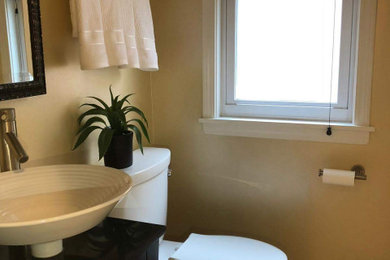 Inspiration for a small contemporary 3/4 marble floor, beige floor and single-sink bathroom remodel in Chicago with dark wood cabinets, a two-piece toilet, beige walls, a vessel sink and a freestanding vanity