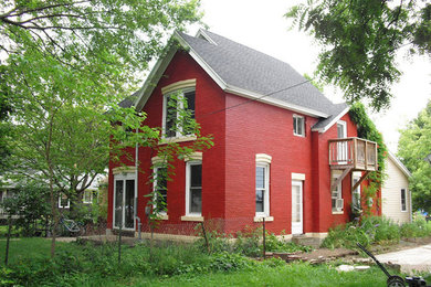 Inspiration for a red two-story brick exterior home remodel in Other