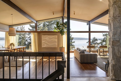 Inspiration for a large mid-century modern medium tone wood floor, exposed beam and wallpaper living room remodel in Seattle with beige walls