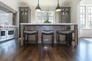 Kitchen - transitional kitchen idea in St Louis with a farmhouse sink, beige backsplash, stainless steel appliances and an island