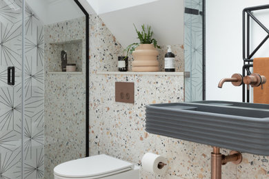 Inspiration for a mid-sized contemporary 3/4 bathroom in London with an alcove shower, a wall-mount toilet, multi-coloured walls, a niche and a single vanity.