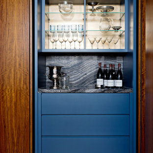 Foto di un angolo bar senza lavandino minimal di medie dimensioni con ante lisce, ante blu, top in granito, paraspruzzi multicolore, paraspruzzi in granito, pavimento in legno massello medio, pavimento marrone e top multicolore