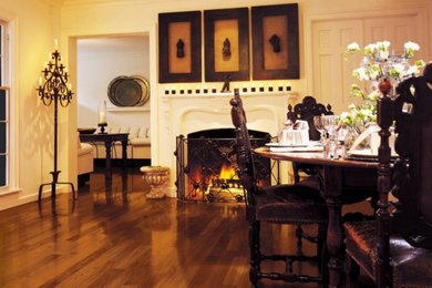 Example of a large classic medium tone wood floor and brown floor enclosed dining room design in Other with beige walls and a standard fireplace