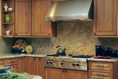 Inspiration for a mid-sized timeless u-shaped light wood floor eat-in kitchen remodel in San Francisco with an undermount sink, raised-panel cabinets, medium tone wood cabinets, granite countertops, multicolored backsplash, stone slab backsplash, stainless steel appliances and a peninsula