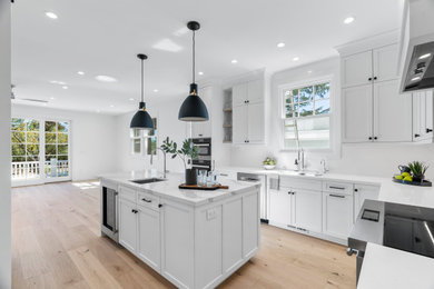 Mid-sized transitional u-shaped brown floor eat-in kitchen photo in San Francisco with flat-panel cabinets, white cabinets, quartz countertops, white backsplash, ceramic backsplash, an island and white countertops