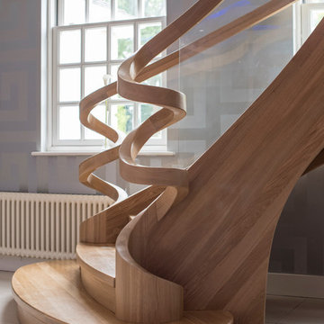 oak curved staircase with a roller coaster balustrade