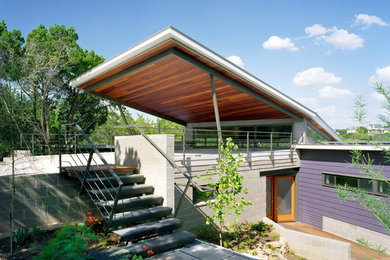 Example of a large trendy purple two-story mixed siding flat roof design in Austin