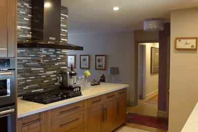 Example of a mid-sized transitional single-wall eat-in kitchen design in Other with a drop-in sink, flat-panel cabinets, light wood cabinets, granite countertops, gray backsplash, ceramic backsplash, stainless steel appliances and no island