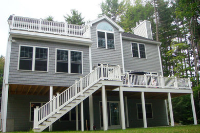 Inspiration for a large contemporary gray two-story vinyl exterior home remodel in Manchester with a shingle roof
