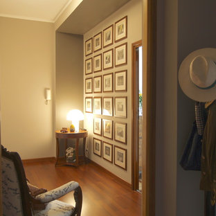 Photo of a mid-sized eclectic foyer in Milan with beige walls, painted wood floors and brown floor.