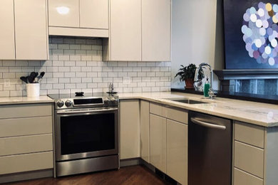 Inspiration for a mid-sized modern u-shaped dark wood floor and brown floor enclosed kitchen remodel in Calgary with a single-bowl sink, flat-panel cabinets, white cabinets, quartzite countertops, white backsplash, subway tile backsplash, stainless steel appliances, a peninsula and white countertops
