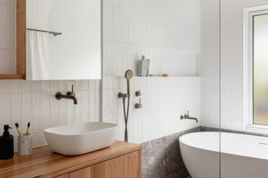 Inspiration for a contemporary wet room bathroom in Melbourne with medium wood cabinets, a freestanding tub, white tile, subway tile, porcelain floors, a vessel sink, wood benchtops, grey floor, an open shower, a single vanity and a floating vanity.