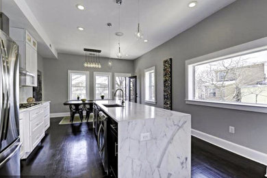 Inspiration for a mid-sized modern single-wall dark wood floor eat-in kitchen remodel in DC Metro with an undermount sink, shaker cabinets, white cabinets, marble countertops, white backsplash, ceramic backsplash, stainless steel appliances and an island