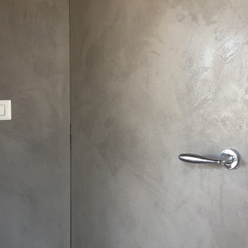 Stucco Moderno su parete con porta a filo muro e cassetti.