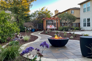 Inspiration for a mid-sized 1950s backyard concrete paver patio remodel in San Francisco with a fire pit and no cover