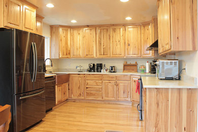 Kitchen - u-shaped brown floor kitchen idea in Other with raised-panel cabinets, light wood cabinets, stainless steel appliances, no island and white countertops